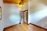 This inviting room boasts a warm ambiance with its wooden floors and ceiling beams.
