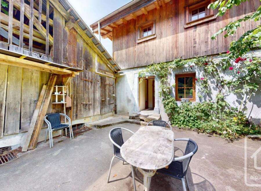 This charming property showcases traditional architecture with a rustic wooden facade complemented by lush greenery.
