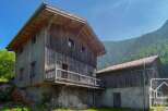 Discover this unique mountain property, a rustic wooden chalet nestled amidst lush greenery.