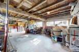 This is a spacious garage with exposed wooden beams, offering a rustic charm and ample storage.