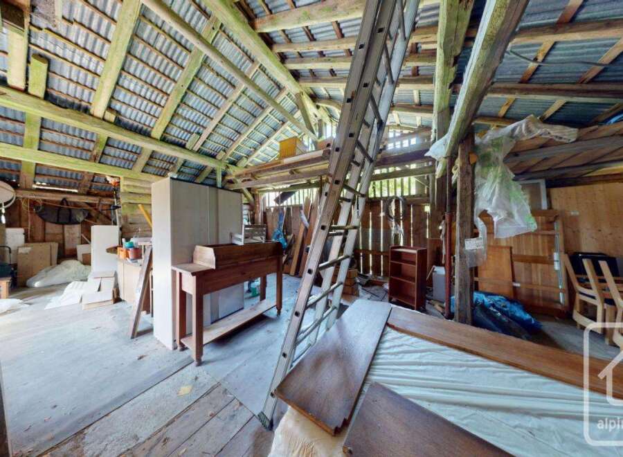 Discover the potential of this rustic barn featuring a spacious interior with exposed wooden beams and a high ceiling.