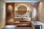 This modern bathroom features a sleek design with a floating double vanity, a round illuminated mirror, and a luxurious bathtub.