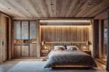 This bedroom showcases a warm, rustic design with extensive use of wood paneling on the walls, ceiling, and flooring, creating a cozy, natural ambiance.