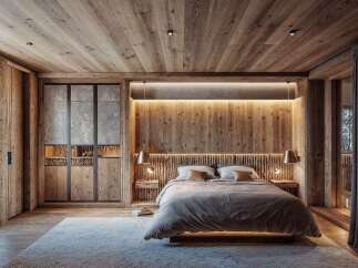 This bedroom showcases a warm, rustic design with extensive use of wood paneling on the walls, ceiling, and flooring, creating a cozy, natural ambiance.