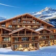 A luxurious chalet nestled in a snowy mountain landscape, featuring multiple balconies and expansive windows.