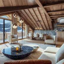 This luxurious chalet boasts stunning mountain views visible through large windows, seamlessly blending indoor comfort with the beauty of nature.