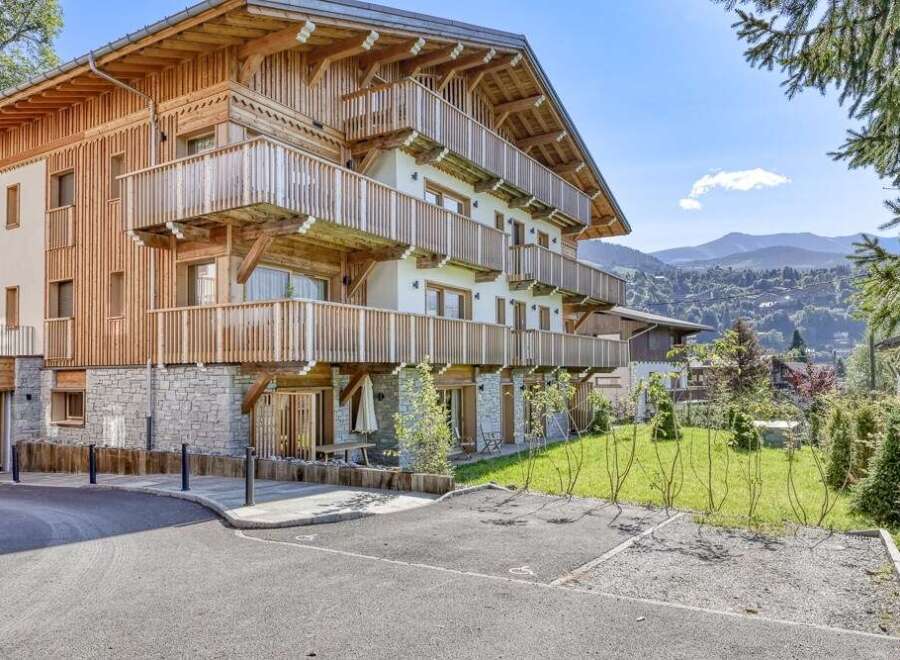 Discover this stunning chalet-style apartment building with wooden balconies, offering breathtaking mountain views.