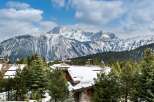 Experience luxury living in this stunning mountain chalet, complete with snow-covered rooftops and breathtaking views.