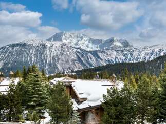 Experience luxury living in this stunning mountain chalet, complete with snow-covered rooftops and breathtaking views.