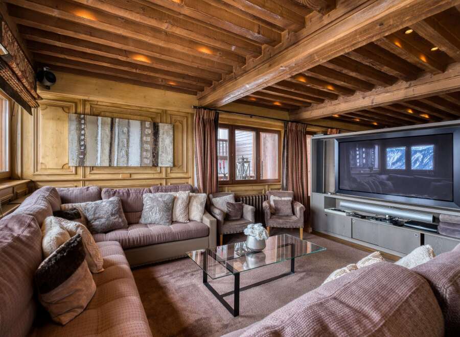 This luxurious living room features a stunning wood beam ceiling with recessed lighting, creating a warm and inviting ambiance.