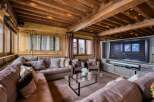 This luxurious living room features a stunning wood beam ceiling with recessed lighting, creating a warm and inviting ambiance.