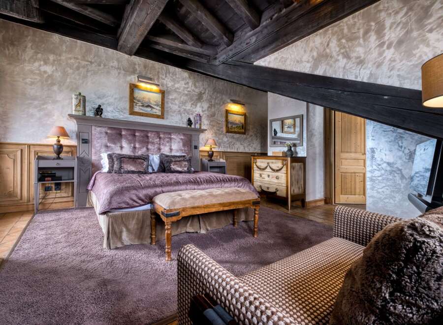 This luxurious bedroom boasts rustic charm with exposed wooden beams, creating a cozy and inviting atmosphere.
