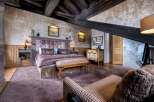 This luxurious bedroom boasts rustic charm with exposed wooden beams, creating a cozy and inviting atmosphere.