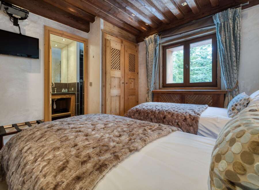 This inviting bedroom features twin beds adorned with plush, faux-fur throws for added comfort.