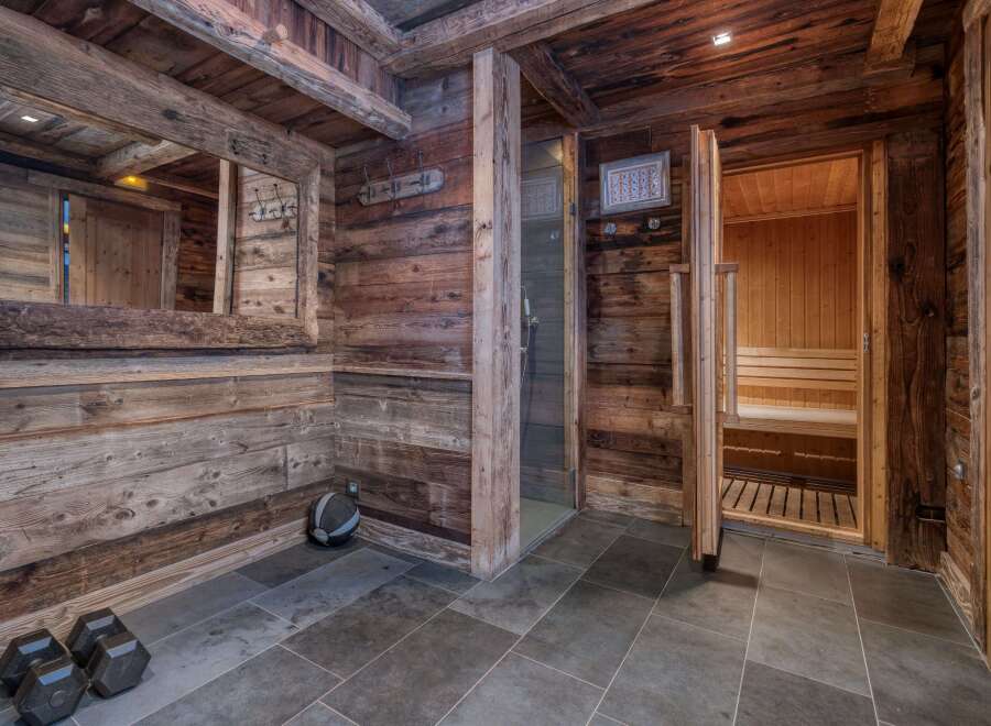 This rustic home spa features wood-paneled walls and ceilings, creating a warm and inviting atmosphere.