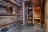 This rustic home spa features wood-paneled walls and ceilings, creating a warm and inviting atmosphere.