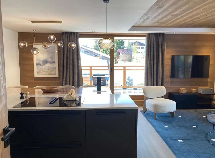 Experience luxury living in this stunning property, featuring a modern kitchen with sleek black cabinetry and a stylish island.