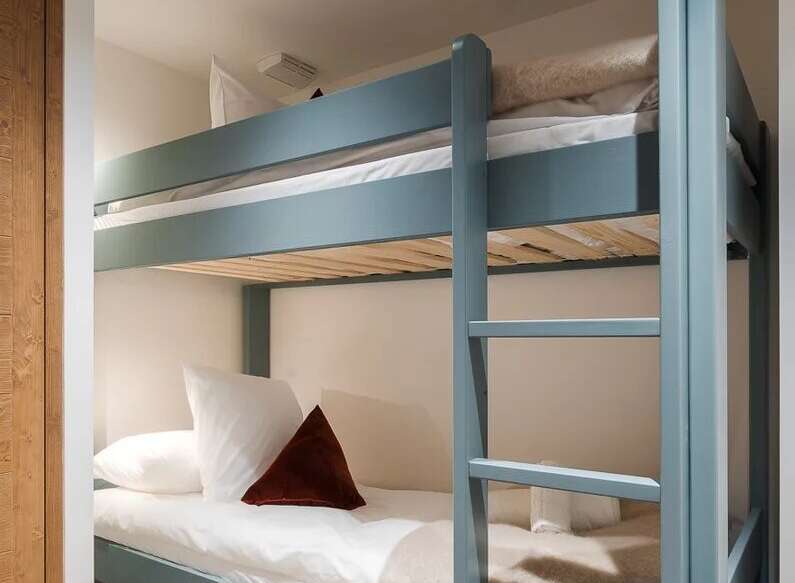 This cozy bunk bed offers a stylish and space-saving solution for any bedroom.