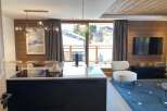 Experience luxury living in this stunning property, featuring a modern kitchen with sleek black cabinetry and a stylish island.