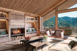 A luxurious living room boasts a cozy fireplace with wood storage, complemented by built-in shelves and seating niches.