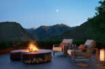 Experience luxury living with this stunning outdoor space featuring a modern fire pit, comfortable seating, and breathtaking mountain views.
