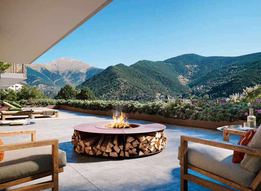 Luxury outdoor living space with a modern fire pit featuring integrated wood storage, perfect for enjoying mountain views.