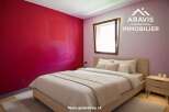 Discover this charming bedroom featuring a vibrant red accent wall, creating a bold and inviting atmosphere.