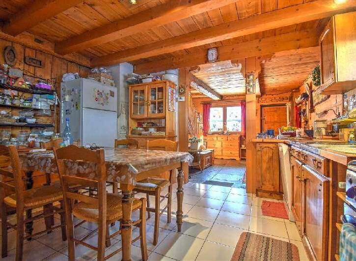 This charming kitchen features wooden beams, cabinets, and walls, creating a warm and inviting atmosphere.