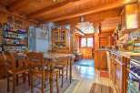 This charming kitchen features wooden beams, cabinets, and walls, creating a warm and inviting atmosphere.