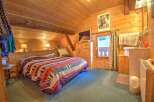 This cozy bedroom features natural wood walls and ceilings, creating a warm and inviting atmosphere.
