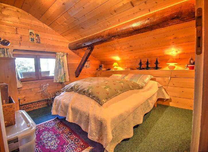 This cozy bedroom features warm wood paneling and exposed beams, creating a rustic and inviting atmosphere.