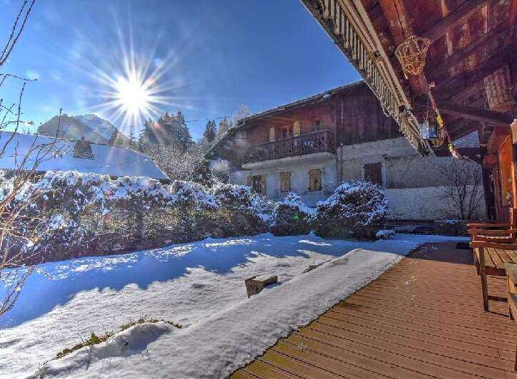 A charming chalet nestled in a snowy landscape offers a serene winter retreat.