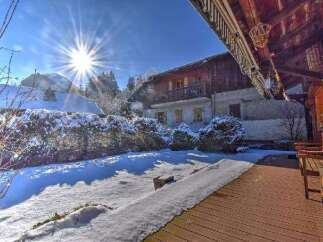 A charming chalet nestled in a snowy landscape offers a serene winter retreat.