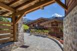 Discover a luxurious chalet nestled in the mountains, featuring stunning wooden architecture and a charming stone pathway.