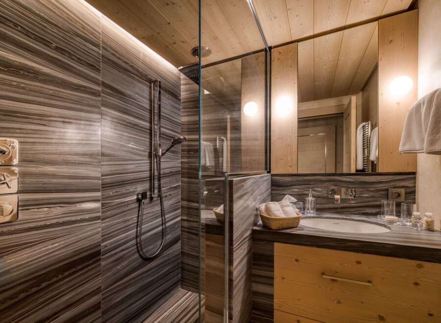 This bathroom showcases a luxurious design with a focus on natural materials.