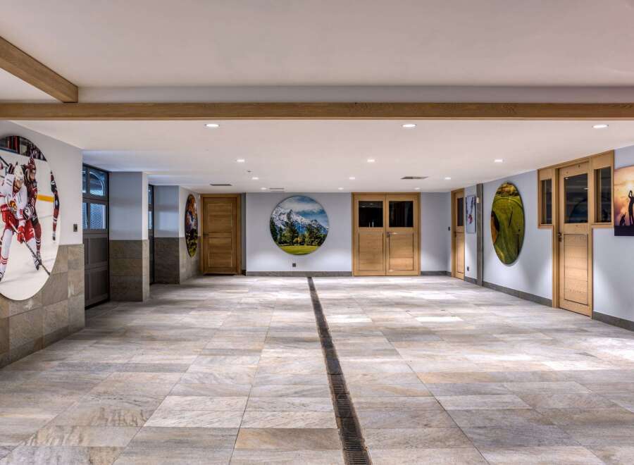 This spacious indoor area boasts a unique blend of sporting and nature-themed decor, with large circular art pieces featuring hockey, mountains, and golf.