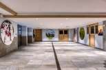 This spacious indoor area boasts a unique blend of sporting and nature-themed decor, with large circular art pieces featuring hockey, mountains, and golf.