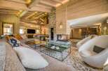 This grand living room boasts natural wood finishes, a stone fireplace, and plush seating.