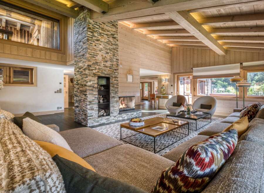 Experience the ultimate in cozy luxury with this chalet's stunning stone fireplace, wood-paneled walls, and exposed beam ceiling.