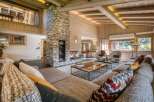 Experience the ultimate in cozy luxury with this chalet's stunning stone fireplace, wood-paneled walls, and exposed beam ceiling.