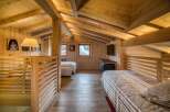Discover this charming attic bedroom, a cozy retreat featuring natural wood paneling on the walls, ceiling, and floor for a warm, rustic ambiance.