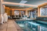 This stunning property boasts an indoor pool with seamless transition to a cozy seating area.