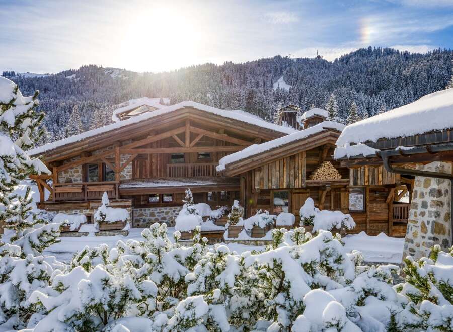 A stunning wooden chalet nestled in a snow-covered landscape, perfect for a winter getaway.