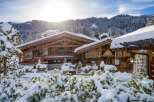 A stunning wooden chalet nestled in a snow-covered landscape, perfect for a winter getaway.