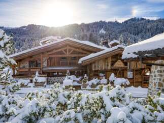 A stunning wooden chalet nestled in a snow-covered landscape, perfect for a winter getaway.