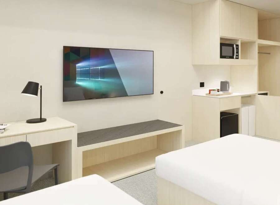 This modern studio apartment features a sleek design, with built-in storage, a kitchenette, and a workspace.