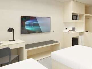 This modern studio apartment features a sleek design, with built-in storage, a kitchenette, and a workspace.