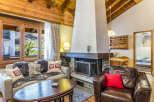 Experience cozy mountain living in this charming chalet featuring a stone fireplace and wood-paneled walls.