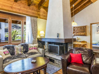 Experience cozy mountain living in this charming chalet featuring a stone fireplace and wood-paneled walls.