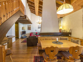 Step into this charming chalet-style home, featuring a cozy dining area with wooden furniture and a unique fireplace.